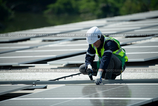 Engineer in charge of solar panel installation The installation of solar energy conversion into electricity for a warehouse is currently being investigated. Стоковое фото, агентство Ingram Publishing / Фотобанк Лори