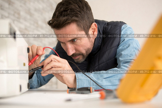engineer using a voltage and current tester. Стоковое фото, агентство Ingram Publishing / Фотобанк Лори