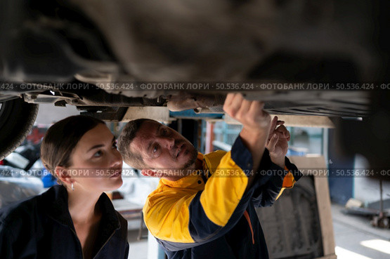 Engineers and auto repair technicians must use technology to detect faults in the operation of the engine of customer cars brought to repair in the garage. Стоковое фото, агентство Ingram Publishing / Фотобанк Лори