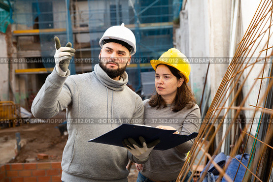 Engineers discussing blueprint at construction site. Стоковое фото, фотограф Яков Филимонов / Фотобанк Лори