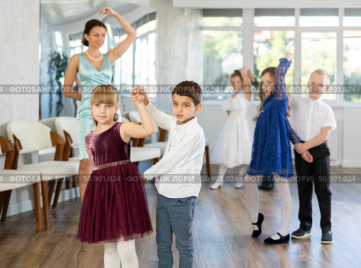 Enthusiastic preteen children dancing waltz in pairs in dance school. Стоковое фото, фотограф Яков Филимонов / Фотобанк Лори