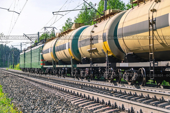 Еревозка нефтехимических продуктов в железнодорожной цистерне. Вагоны тянут два локомотива. Перевозка нефтепродуктов по железной дороге. Вагоны со сжиженным газом. Стоковое фото, фотограф Эдуард Белкин / Фотобанк Лори