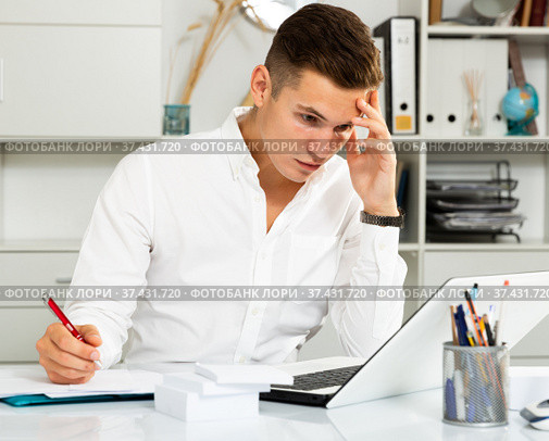 european guy in white shirt puzzled by problems in office. Стоковое фото, фотограф Татьяна Яцевич / Фотобанк Лори