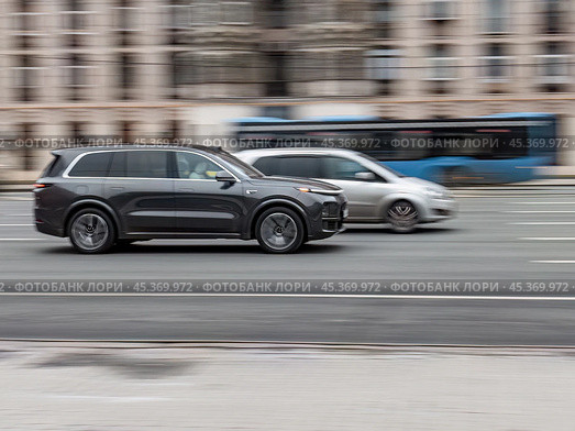 EV crossover SUV Lixiang L9 driving in motion blur on city streets. Редакционное фото, фотограф Константин Григорьев / Фотобанк Лори