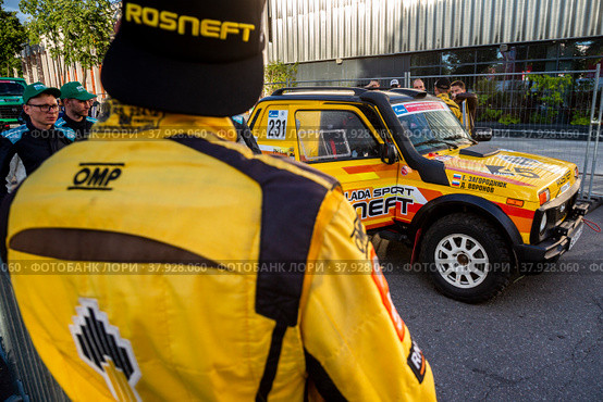 Евгений Загороднюк у автомобиля команды LADA Sport ROSNEFT Raid принимает участие во время торжественной церемонии награждения участников международного ралли "Шелковый путь" в "Лужниках" города Москвы, Россия (2022 год). Редакционное фото, фотограф Николай Винокуров / Фотобанк Лори