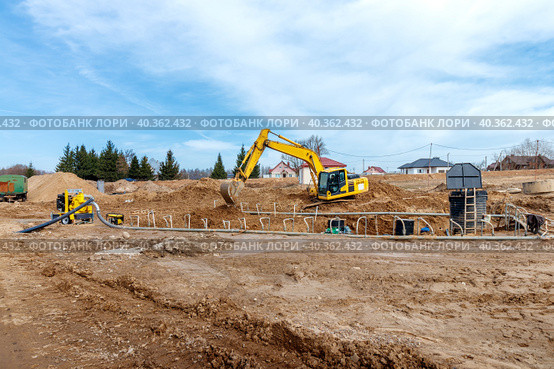 Excavator dig the trenches at a construction site. Trench for laying external sewer pipes. Sewage drainage system for a multi-story building. Digging the pit foundation. Стоковое фото, фотограф Дмитрий Головач / Фотобанк Лори