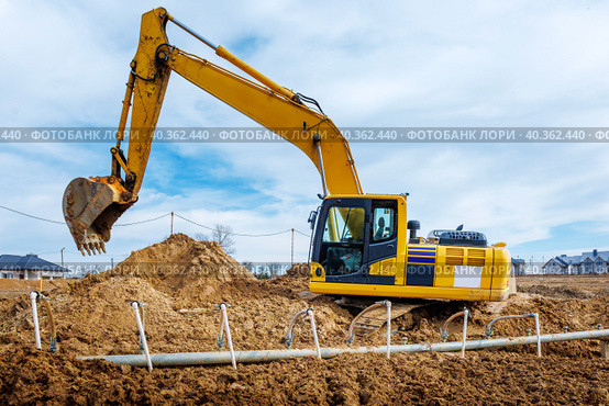 Excavator dig the trenches at a construction site. Trench for laying external sewer pipes. Sewage drainage system for a multi-story building. Digging the pit foundation. Стоковое фото, фотограф Дмитрий Головач / Фотобанк Лори