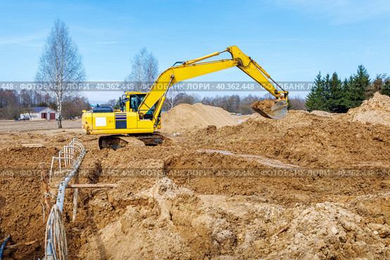 Excavator dig the trenches at a construction site. Trench for laying external sewer pipes. Sewage drainage system for a multi-story building. Digging the pit foundation. Стоковое фото, фотограф Дмитрий Головач / Фотобанк Лори