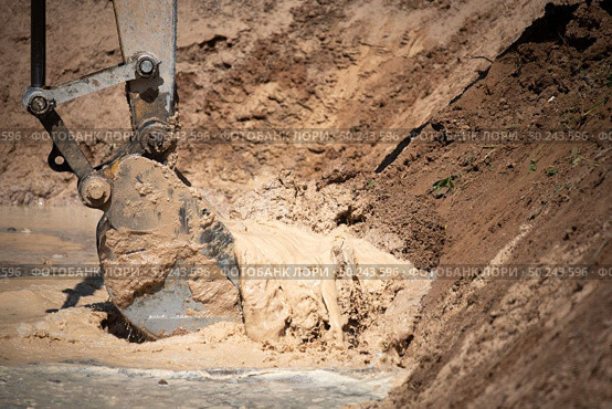 Excavator working with soil and water, during earthmoving works. Стоковое фото, агентство Ingram Publishing / Фотобанк Лори