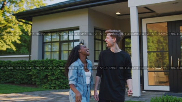 Excited Couple Celebrates Homeownership with Keys in Hand, Enjoying a Beautiful Day Outside Their New Dream House. Стоковое AI-видео, аниматор Владимир Федоров / Фотобанк Лори