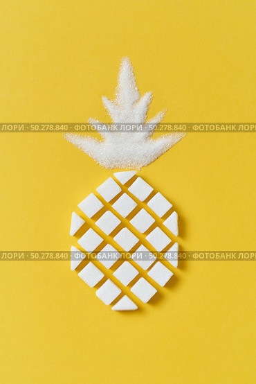 Exotic fruits composition creative pineapple handmade from rafined anf granulated sweet sugar on a yellow background with copy space. Flat lay.. Pineapple fruit handmase from pressed and granulated sweet sugar. Стоковое фото, агентство Ingram Publishing / Фотобанк Лори