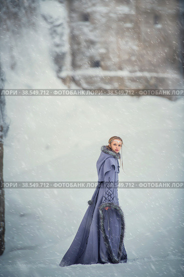 Fabulous girl elf walks near an ancient fortress and snow-covered winter nature. Стоковое фото, фотограф Мария Мороз / Фотобанк Лори