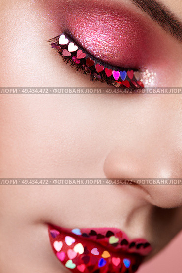 Face of Beautiful Woman with Holiday Makeup Heart. Valentine’s Day Make-up. Lips in Pink Lipstick. Makeup detail. Face of Girl on a Pink Background. Lashes Which are Glued with Hearts. Стоковое фото, агентство Ingram Publishing / Фотобанк Лори