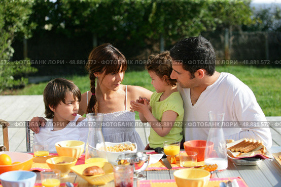 Family having brunch outside on a sunny day. Стоковое фото, агентство Ingram Publishing / Фотобанк Лори