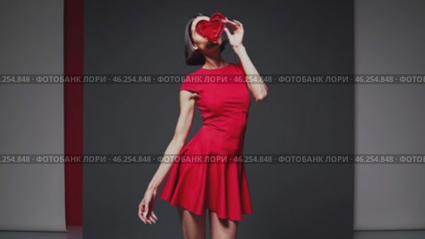 Fashion model posing with red heart, studio shot. Стоковое видео, видеограф Данил Руденко / Фотобанк Лори