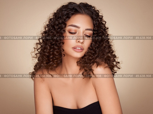 Fashion studio portrait of beautiful smiling woman with afro curls hairstyle. Fashion and beauty. Стоковое фото, агентство Ingram Publishing / Фотобанк Лори