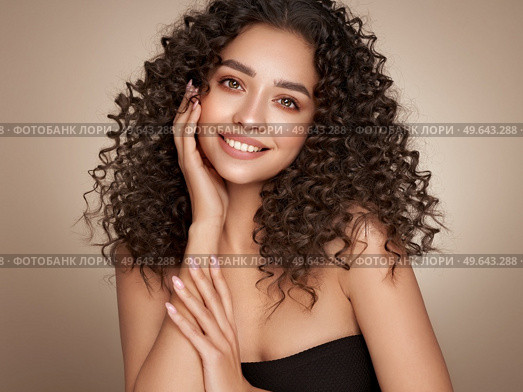 Fashion studio portrait of beautiful smiling woman with afro curls hairstyle. Fashion and beauty. Стоковое фото, агентство Ingram Publishing / Фотобанк Лори