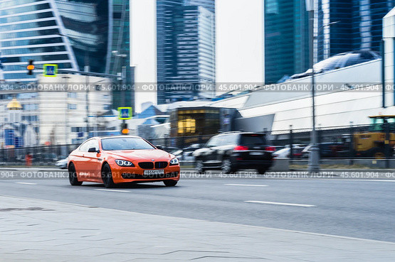 Fast moving orange sports car on the city road. BMW 640I xDrive on the city street in motion (2021 год). Редакционное фото, фотограф Константин Григорьев / Фотобанк Лори