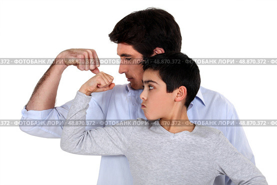 Father and son comparing their muscles. Стоковое фото, агентство Ingram Publishing / Фотобанк Лори