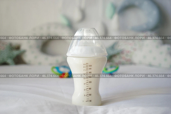 Feeding bottle of baby formula on bed. Стоковое фото, фотограф Pixel_shot / Фотобанк Лори