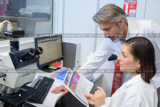 female and male eye doctor sitting with ophthalmologic device. Стоковое фото, агентство Ingram Publishing / Фотобанк Лори