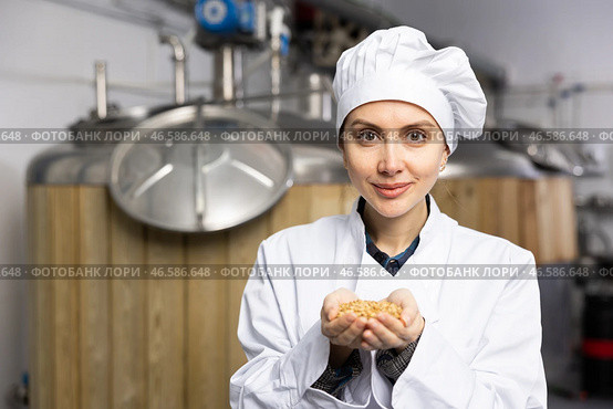 Female brewmaster holding handful of malted barley grain. Стоковое фото, фотограф Яков Филимонов / Фотобанк Лори
