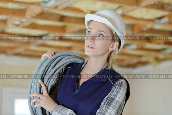 female electrician holding cable indoors. Стоковое фото, агентство Ingram Publishing / Фотобанк Лори
