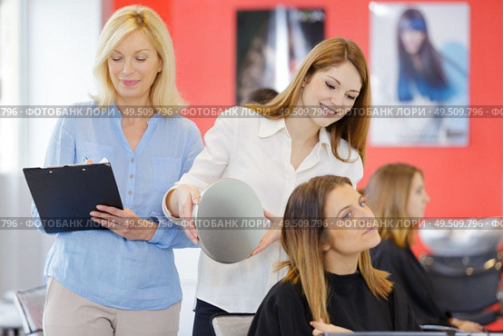 female hairdressing apprentice showing client the cut. Стоковое фото, агентство Ingram Publishing / Фотобанк Лори