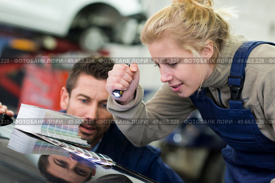 female mechanic with paint samples choosing color car. Стоковое фото, агентство Ingram Publishing / Фотобанк Лори