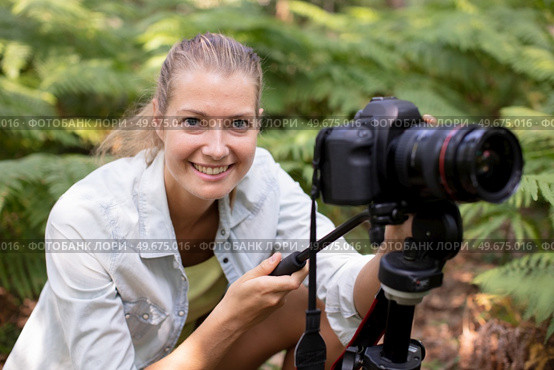 female photographer crouching among ferns. Стоковое фото, агентство Ingram Publishing / Фотобанк Лори