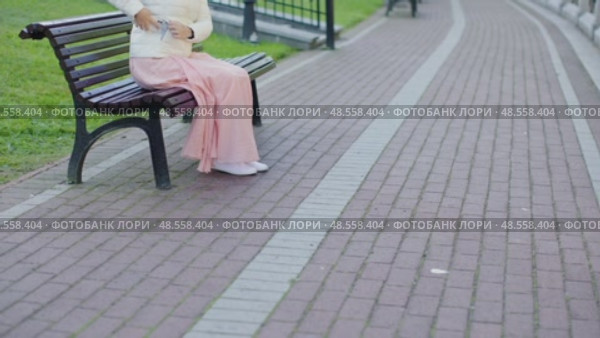 female pink dress white coat sit city park bench stand go away walk on camera. Стоковое видео, видеограф Olesia Kondrateva / Фотобанк Лори