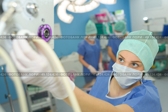 female surgeon setting up medical machine. Стоковое фото, агентство Ingram Publishing / Фотобанк Лори
