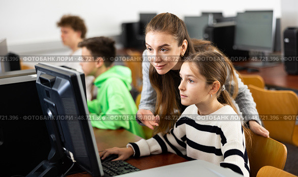 Female teacher consulting teenage girl studying in information technology class. Стоковое фото, фотограф Яков Филимонов / Фотобанк Лори
