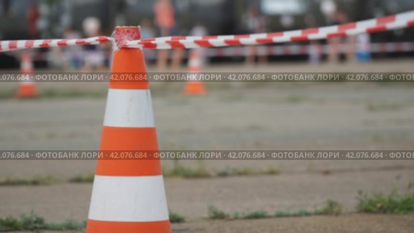 Fencing tape and road cone on the background of passing people. Стоковое видео, видеограф Александр Прошкин / Фотобанк Лори