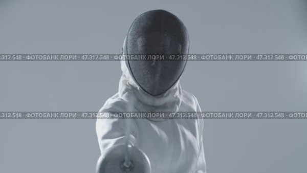 Fencing - young woman fencer in white suit puts on her protective helmet and aiming in the camera with a sword. Стоковое видео, видеограф Константин Шишкин / Фотобанк Лори