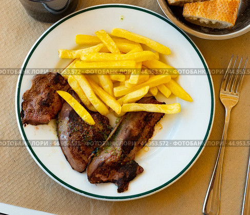 Few pieces of lamb liver are garnished with portion of French fries. Стоковое фото, фотограф Яков Филимонов / Фотобанк Лори