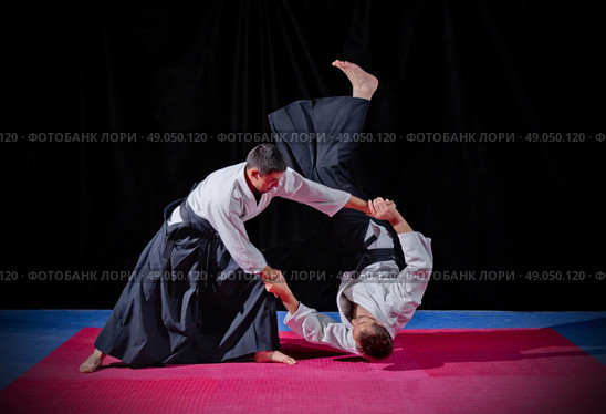 Fight between two aikido fighters on black. Стоковое фото, агентство Ingram Publishing / Фотобанк Лори