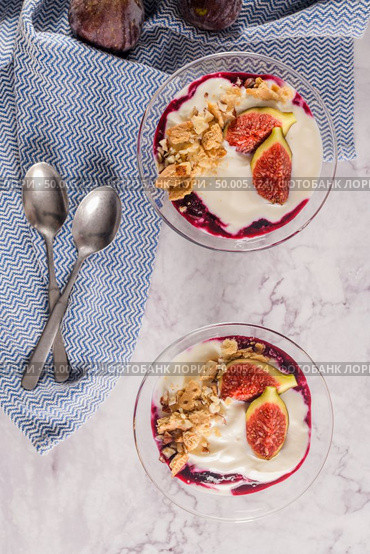 Figs pudding parfait with yogurt, blueberry jam, figs, hazelnut, and cookies in glass on white marble background. Flatlay top view. Стоковое фото, агентство Ingram Publishing / Фотобанк Лори