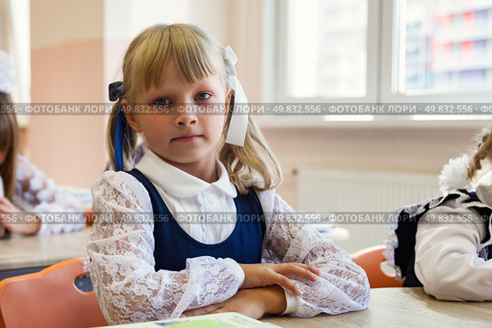 First-grader in a Bright Classroom With a Thoughtful Expression and a Focus on Learning. Стоковое фото, фотограф Aleksandr Golubev / Фотобанк Лори
