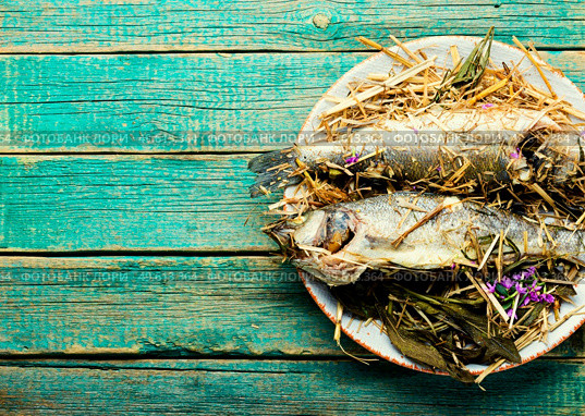 Fish baked in spicy herbs and hay.Roasted sea bass.Copy space. Seabass fish baked with herbs,space for text. Стоковое фото, агентство Ingram Publishing / Фотобанк Лори