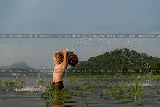 Fishermen using traditional fishing equipment After catching fish, clean up and play in the water. Стоковое фото, агентство Ingram Publishing / Фотобанк Лори