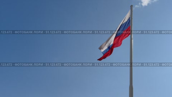 Флаг Российской Федерации на фоне синего чистого неба. Флаг Российской Федерации на флагштоке, развевающийся на ветру, на фоне неба. Стоковое видео, видеограф Терехова Марина / Фотобанк Лори