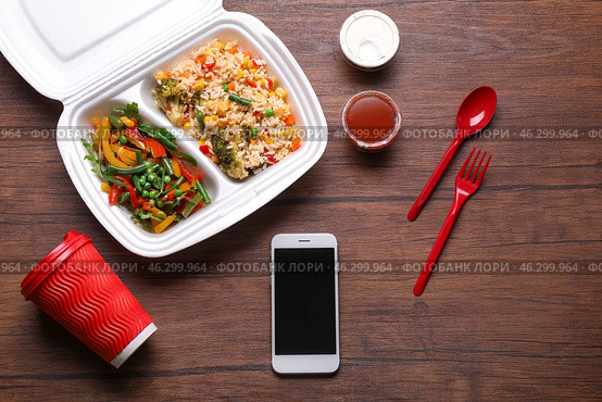 Flat lay composition with smartphone and takeout meal on wooden background. Food delivery. Стоковое фото, фотограф Pixel_shot / Фотобанк Лори