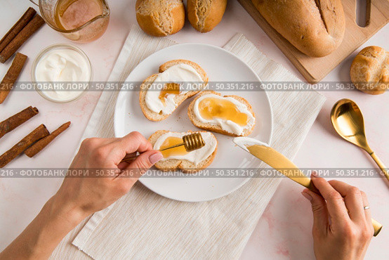 flat lay woman spreading cream cheese bread. Стоковое фото, агентство Ingram Publishing / Фотобанк Лори