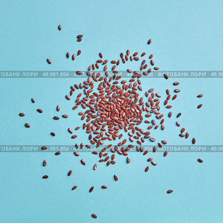 Flaxseed background. Concept of healthy organic vegetarian food. Top view. Flax seeds pattern on blue paper background. Flaxseed or linseed. Стоковое фото, агентство Ingram Publishing / Фотобанк Лори