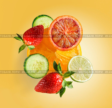 Flying fruits and vegetables group with sliced grapefruit, cucumber, lemon, orange and strawberry levitating on orange background. Healthy refreshing summer food. Front view. Стоковое фото, агентство Ingram Publishing / Фотобанк Лори