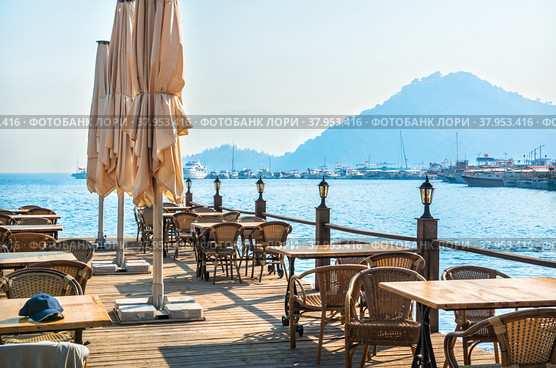 Фонари и столики на пирсе у моря и корабли, Мармарис, Турция (2022 год). Стоковое фото, фотограф Baturina Yuliya / Фотобанк Лори