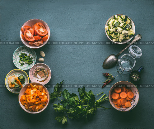 Food background with fresh diced vegetables , cooking spoon and glass jar, top view, frame. Healthy vegetarian food and cooking concept. Homemade lunch in jar making ingredients. Стоковое фото, агентство Ingram Publishing / Фотобанк Лори