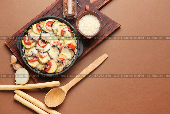 Форма для запекания с вкусной рисовой запеканкой на цветном фоне. Стоковое фото, фотограф Pixel_shot / Фотобанк Лори