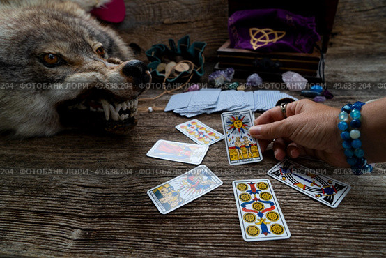 Fortune telling on tarot cards, witch hand is opening cards, used Marseille Tarot deck by unknown artist published first in 1709. Fortune telling on tarot cards. Стоковое фото, агентство Ingram Publishing / Фотобанк Лори